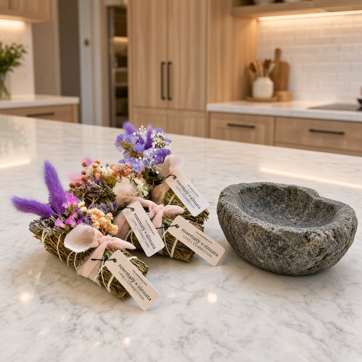 A rustic gray stone mortar bowl with rough edges for holding the rosemary and sinuata smudge stick honoring relationships