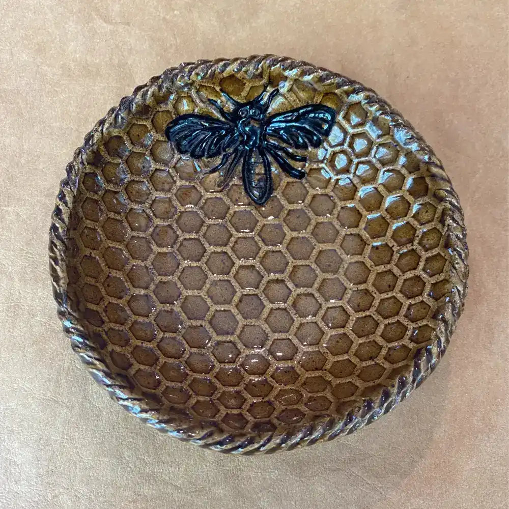 This small handmade pottery dish features a warm mustard honeycomb with an adorable bee design.