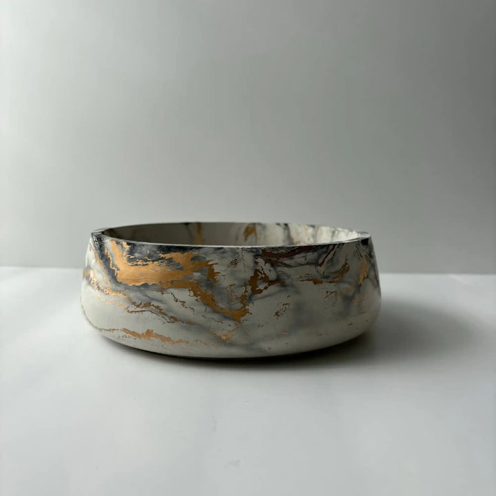 Handmade concrete bowl with marbled swirl design in black, gray, and gold. Smooth, minimalist and modern design.