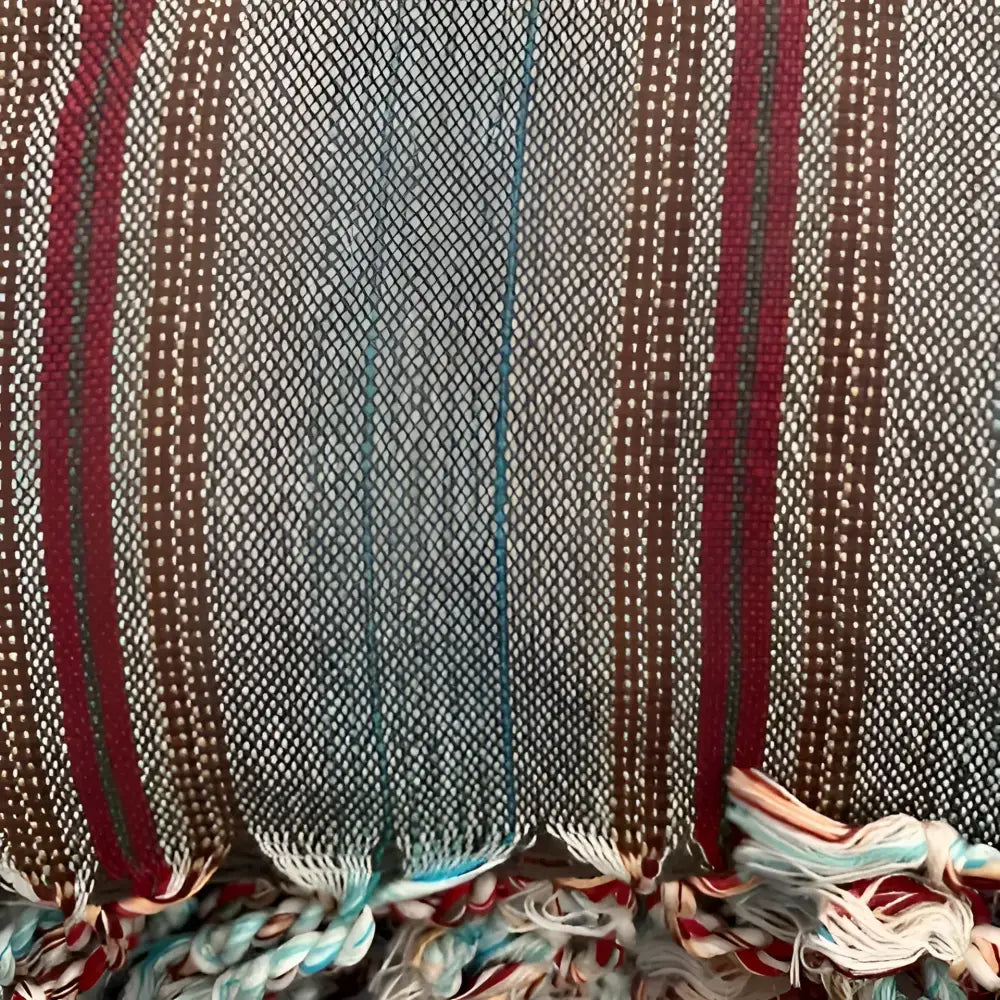 Turkish towel that has a flat weave and has brown, rusty red, and very thin turquoise stripes.