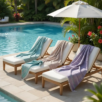 Three wooden lounge chairs with rustic textured teal mauve and lavender handloomed organic cotton towels