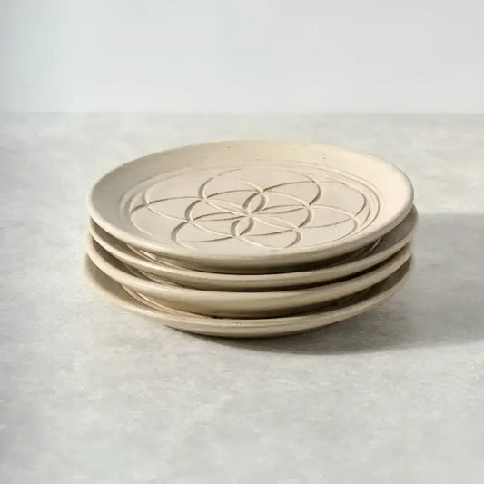 four ceramic plates with a geometric design