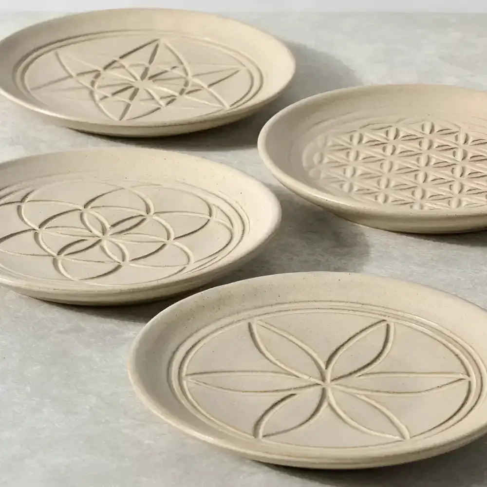four ceramic plates with a geometric design