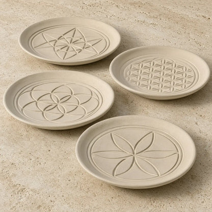 Set of four beige ceramic sacred designs appetizer coasters with unique embossed patterns and geometric designs
