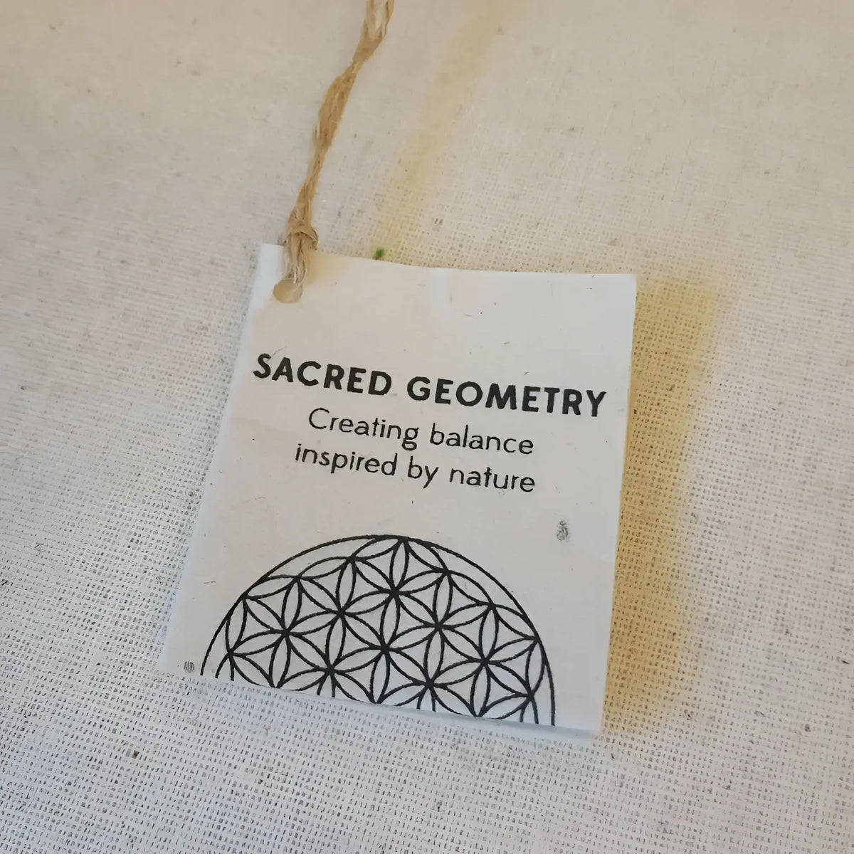 White tag with unique embossed patterns and string on Sacred Designs Appetizer Plates