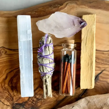 A translucent purple amethyst crystal with natural facets included in a celestial ritual kit for creating intentional space with palo santo stick