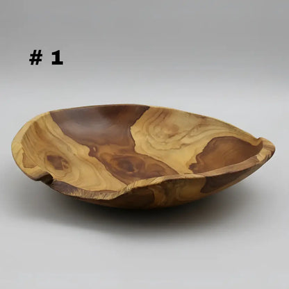 Large live edge hand carved wooden bowl made from salvaged teak roots with warm golden and deep brown grain patterns
