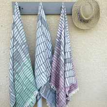 Cotton towel with gauze texture with a geometric woven design and eyelash fringe.