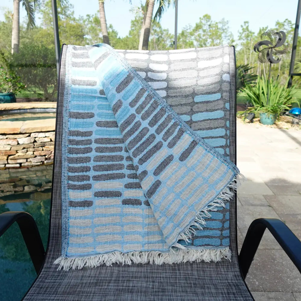 Cotton towel with gauze texture with a geometric woven design and eyelash fringe.