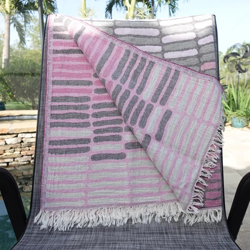 Cotton towel with gauze texture with a geometric woven design and eyelash fringe.