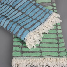 Cotton towel with gauze texture with a geometric woven design and eyelash fringe.