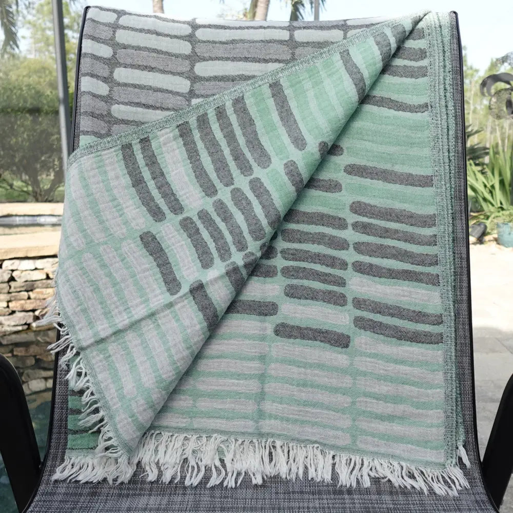 Cotton towel with gauze texture with a geometric woven design and eyelash fringe.
