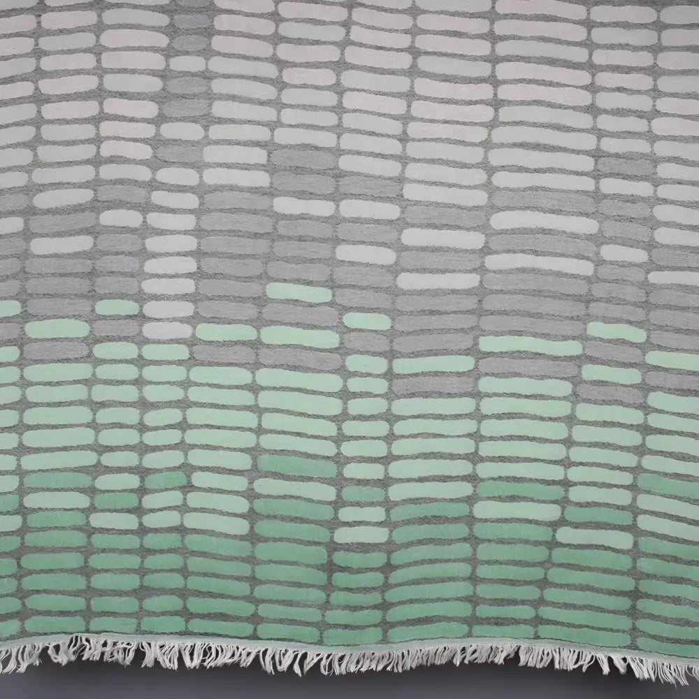 Cotton towel with gauze texture with a geometric woven design and eyelash fringe.