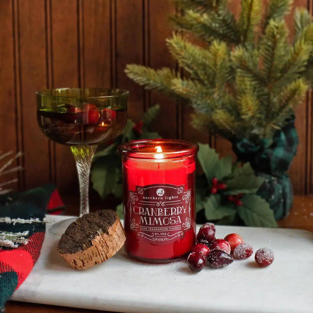 Red glass jar candle from Seasonal Spirit Candles inspired by favorite holiday cocktails flickering flame for festive mood