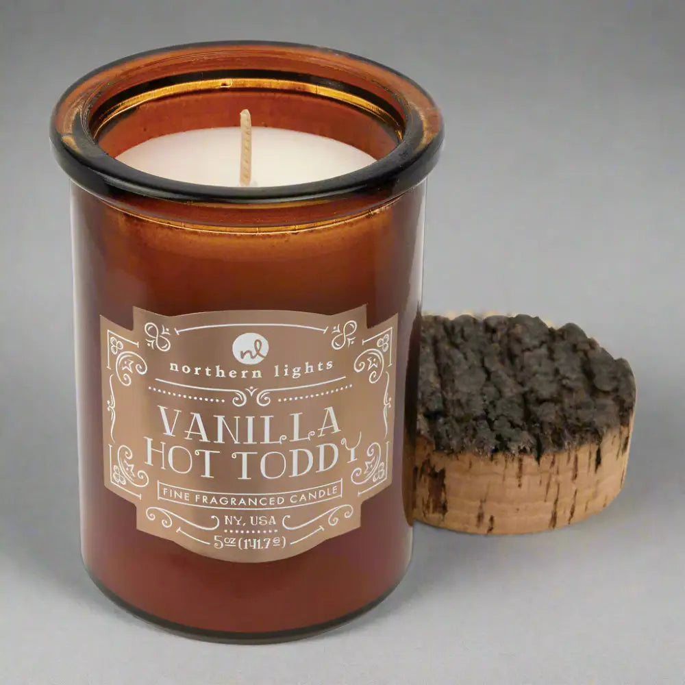 Amber glass jar candle with wooden wick and cork lid from Seasonal Spirit Candles inspired by favorite holiday cocktails for a festive mood