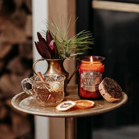 Lit scented candle in glass jar from Seasonal Spirit Candles inspired by favorite holiday cocktails for a festive mood