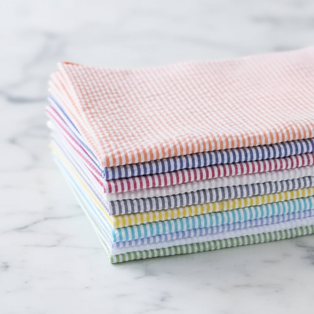 Handcrafted seersucker cloth napkins set of eight in pastel stripes on wood