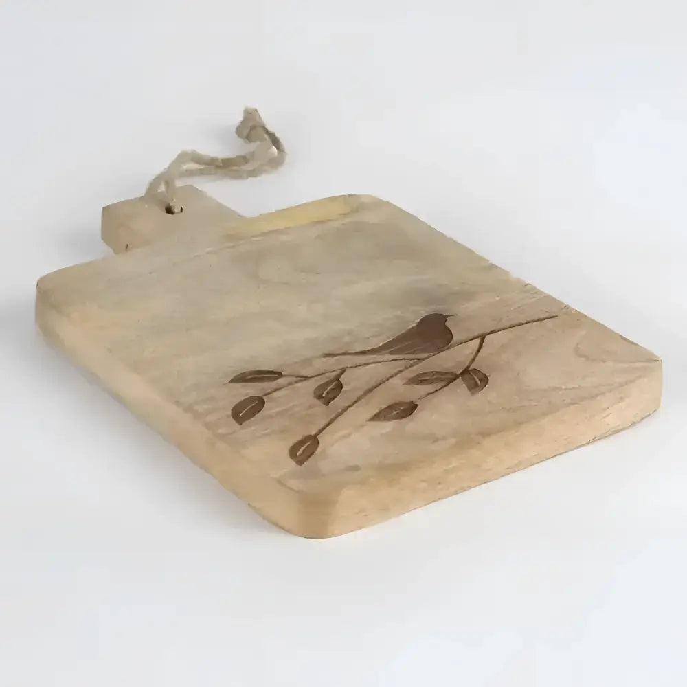 wooden serving board with etched bird on branch on a light background