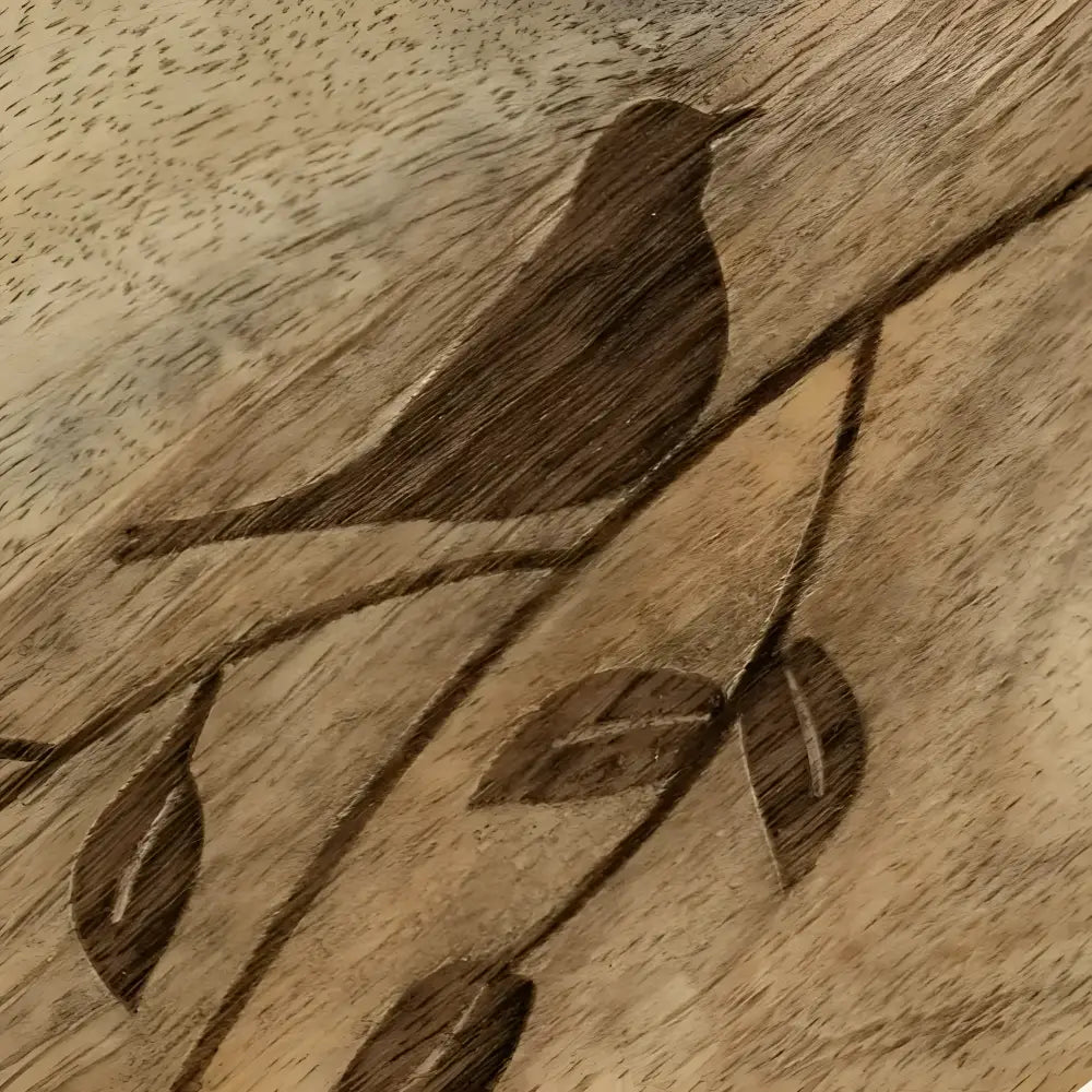 wooden serving board with etched bird on branch.