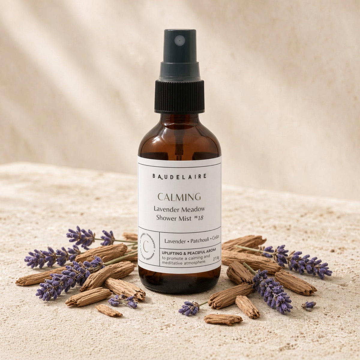 A brown glass shower spray mist bottle labeled baudelaire calming lavender meadow surrounded by dried lavender sprigs