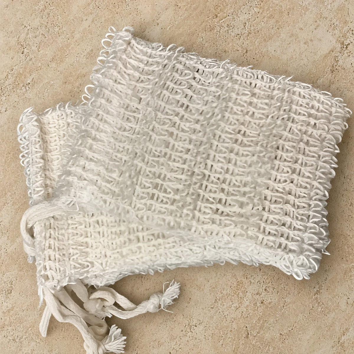 White textured woven sisal soap saver bag with drawstring closure for gentle exfoliation and soap storage
