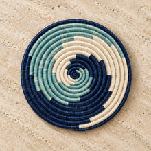 Handwoven sisal trivet in blue wave design with navy teal and cream fibers to protect surfaces in style