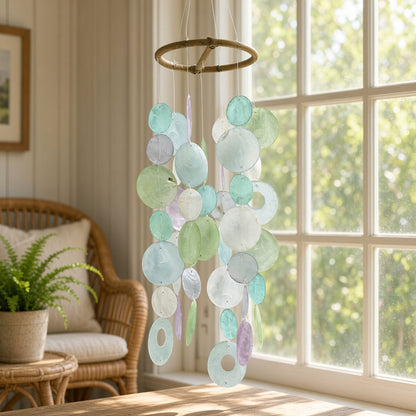 Small round handmade capiz chime with pastel blue green and purple discs on a rustic wooden hoop eco-friendly decor