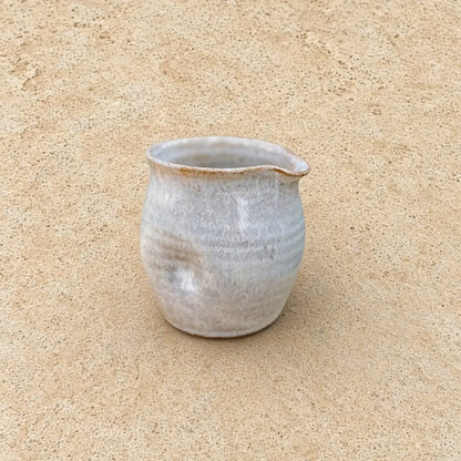 Small thumb divot handmade pitcher in matte gray ceramic with speckled texture perfect for pouring cream and avoiding awkward grip