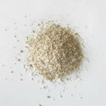 A mound of pale beige soaking salts with coarse translucent crystals featuring mustard seed for cold muscle relief
