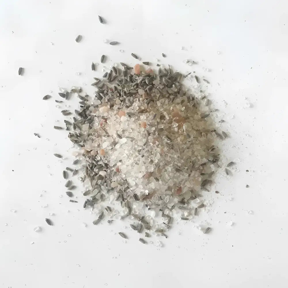 A pile of pink himalayan soaking salts mixed with dried lavender buds for rejuvenate with lavender and herb