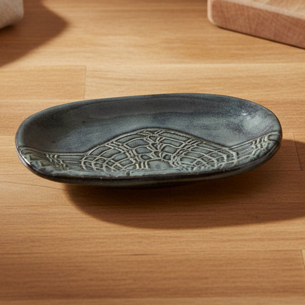 Decorative dish with intricate designs on a neutral background