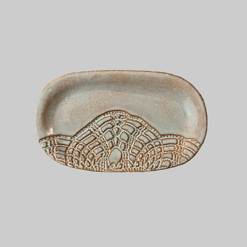 Decorative dish with lace pattern on a granite surface