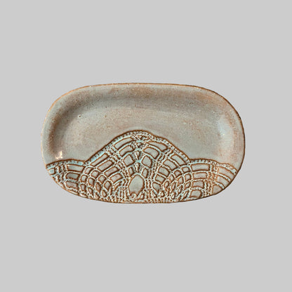 Decorative dish with lace pattern on a granite surface