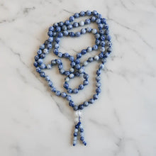A blue and white speckled sodalite beads mala with clear crystal pendant perfect for mantra chanting and meditation companion
