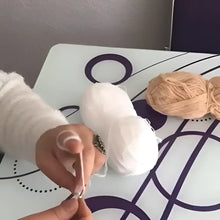 Hands holding a crochet hook and white yarn for a soft organic cotton shower pouf