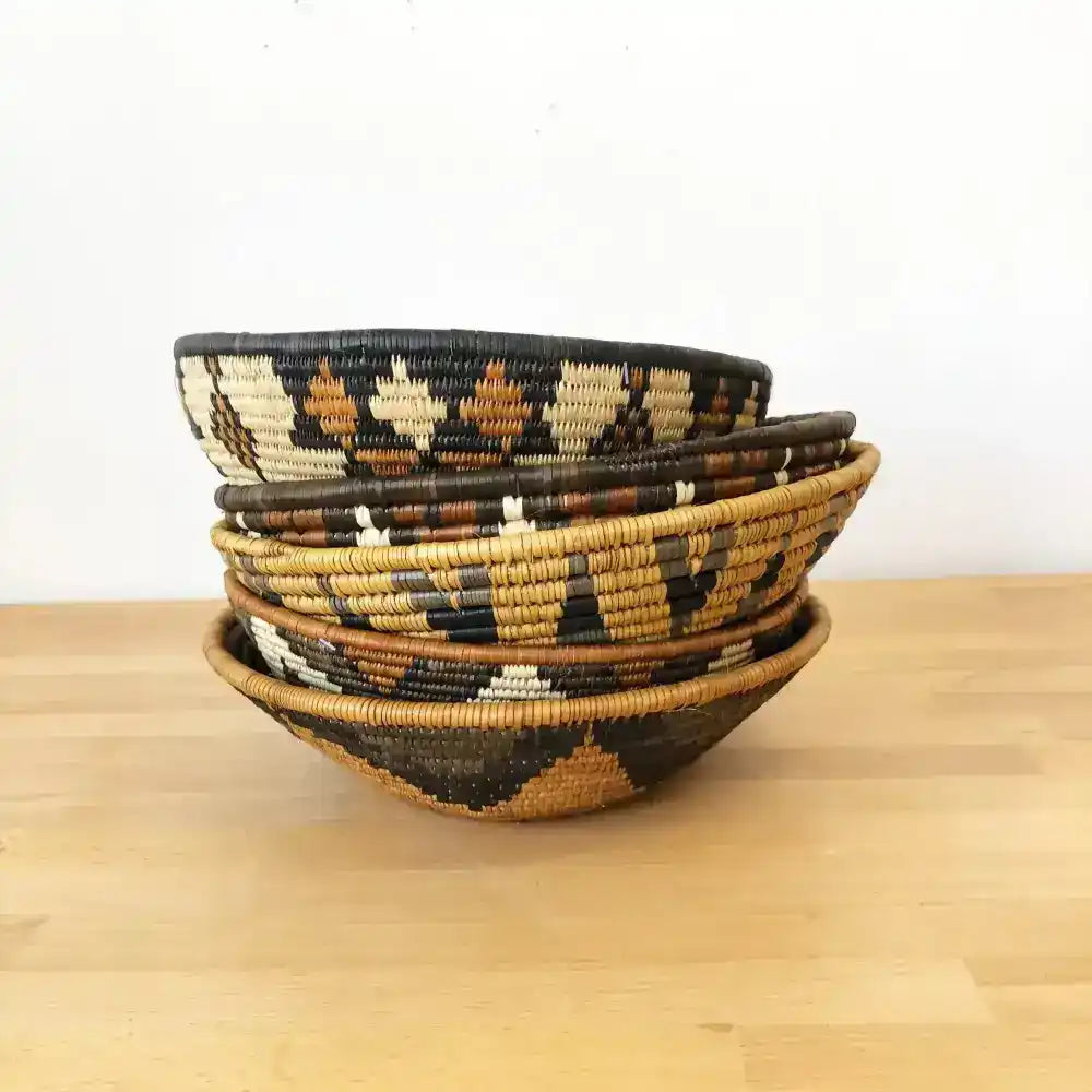 Assorted handmade African baskets in various natural colors with striking geometric designs.