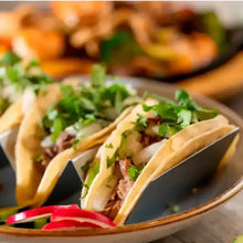 Four street tacos in stainless steel upright taco rack for easy serving and holding