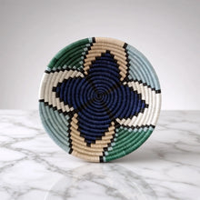 Handwoven star small sisal bowl with geometric pattern in navy, teal, cream, and black featuring a hanging loop