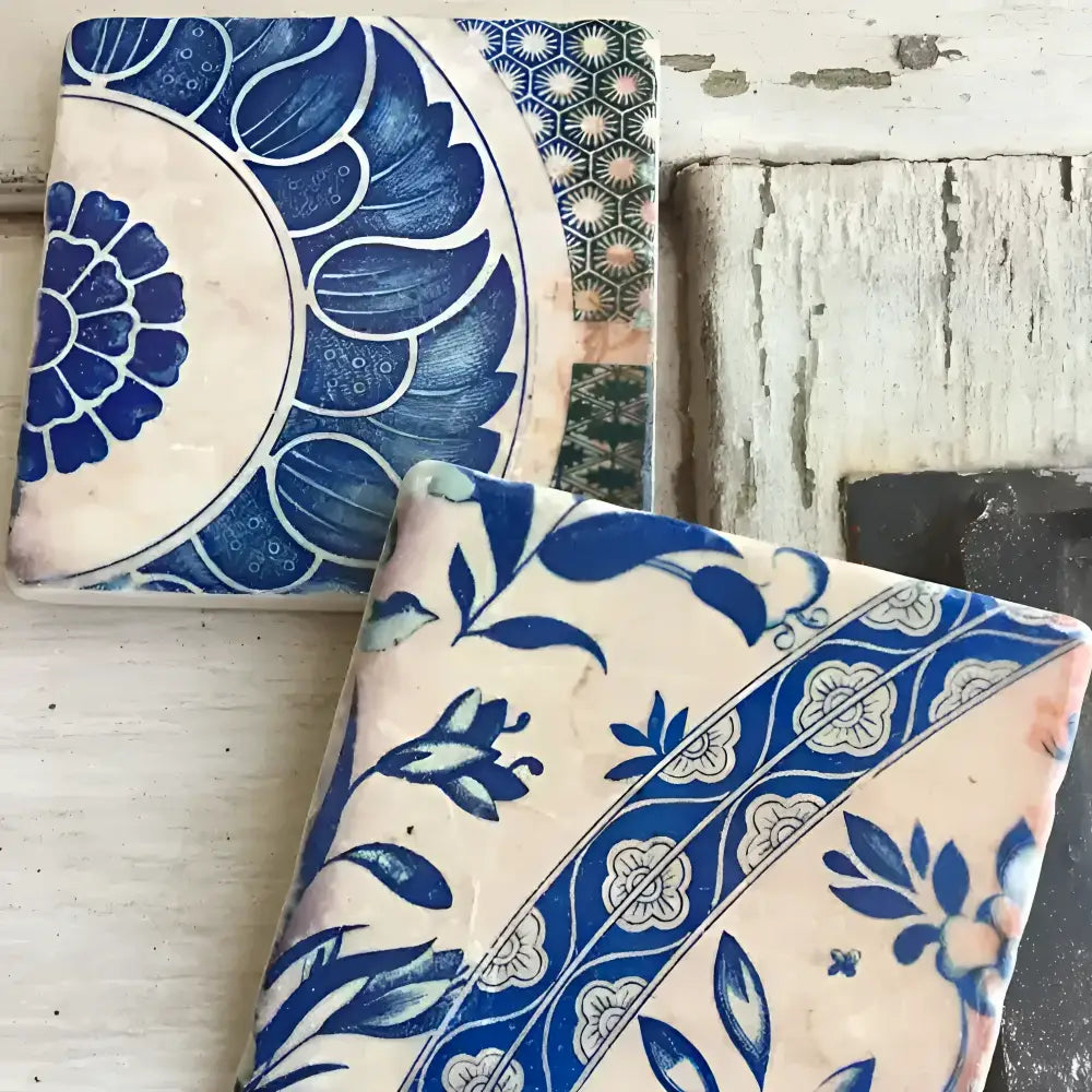 Two ceramic tiles with blue floral patterns on a rustic wooden background