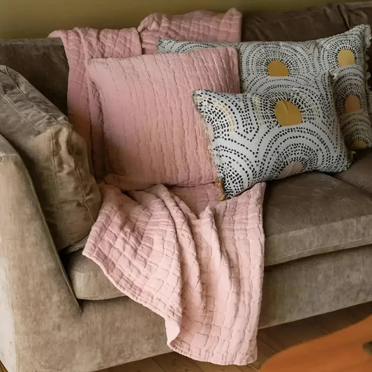 Cozy sofa with pink plush pillows and stonewashed cotton lightweight quilt in king size