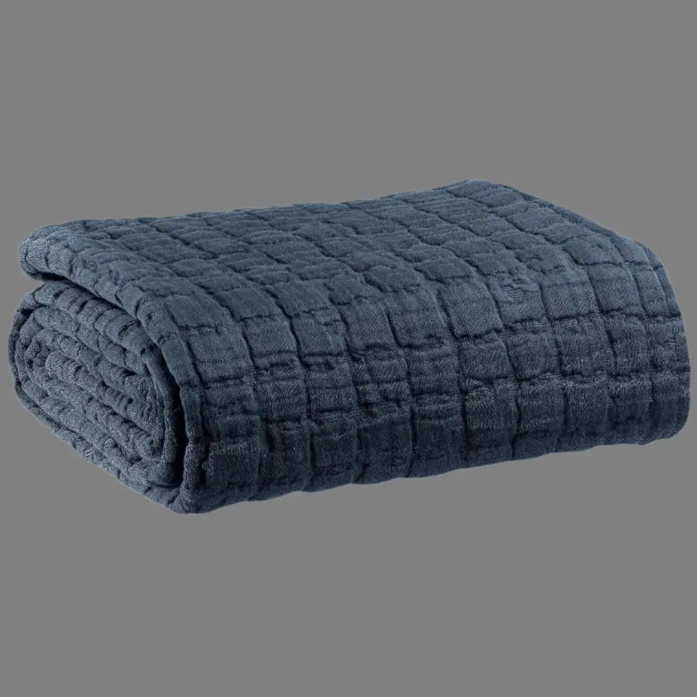 Folded navy blue textured blanket on a white background