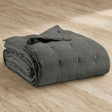 A dark gray stonewashed bed runner with soft quilted texture and subtle button detailing for queen or king beds