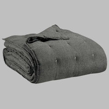 Folded dark gray blanket on a white background