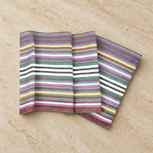Three folded striped handwoven cotton table runners with colorful horizontal stripes in teal green and purple shades