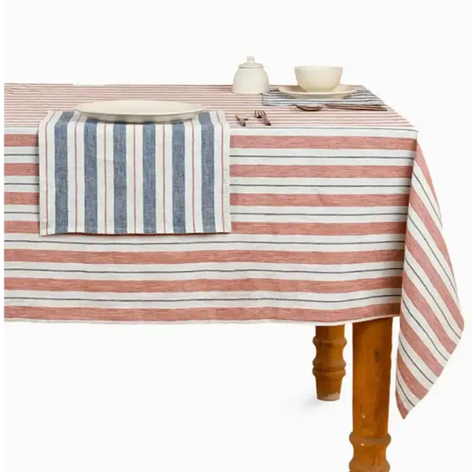 A wooden table with a striped tablecloth on it.