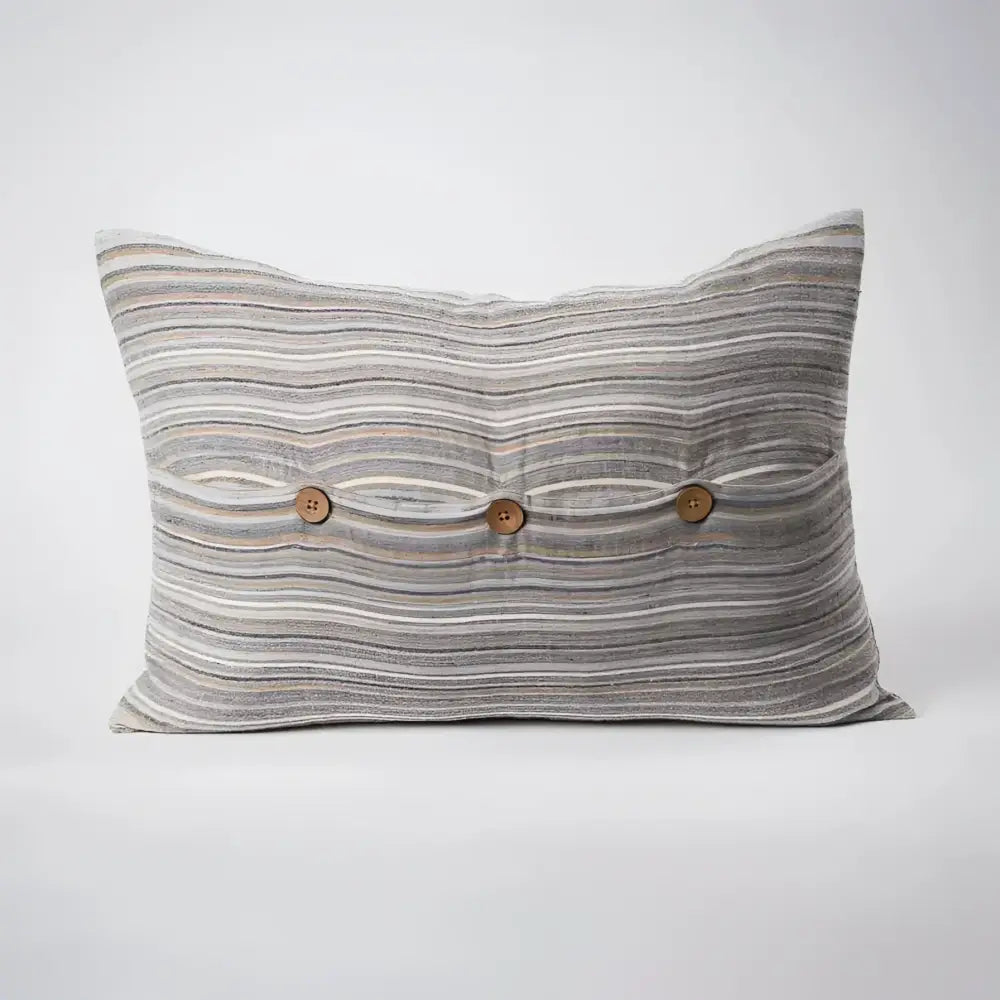 Back side of striped pillow in blues, greens, and natural colors.