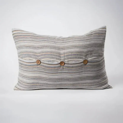 Back side of striped pillow in blues, greens, and natural colors.