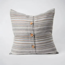 Back side of striped pillow in blues, greens, and natural colors.