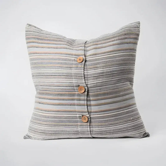Back side of striped pillow in blues, greens, and natural colors.