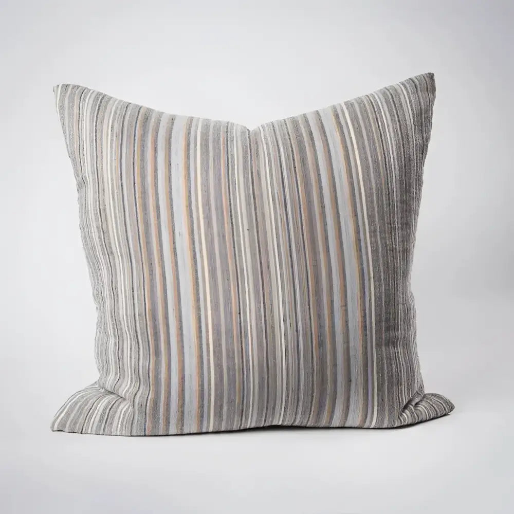 Front side of striped pillow in blues, greens, and natural colors.